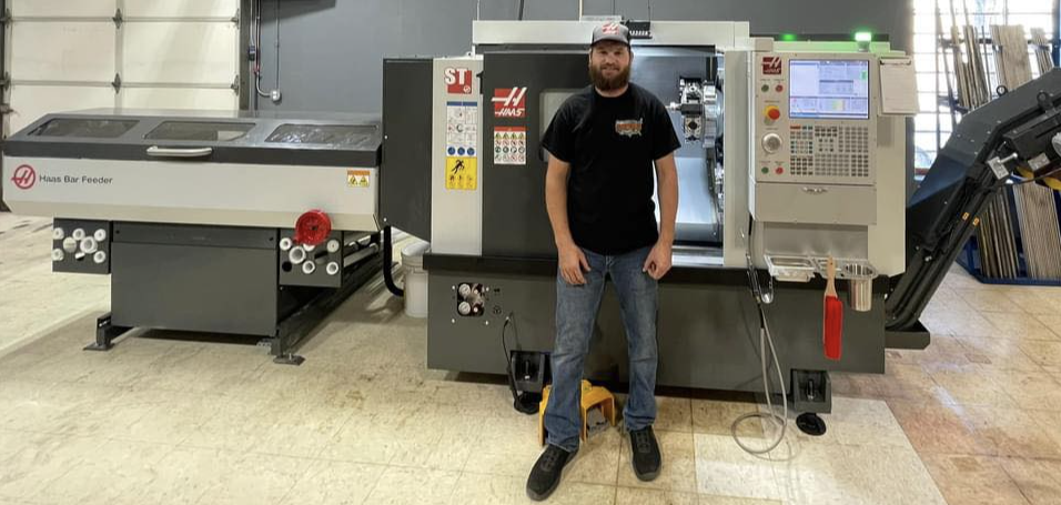 Drew Graff, owner of On Demand Machining, standing in front of a Haas CNC machine